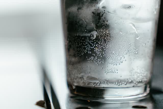 Glass of sparkling water on a dark table