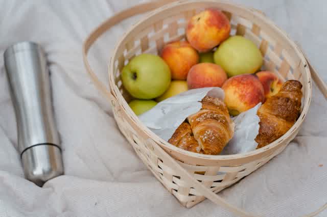 Steel vacuum flask beside a picnic basket